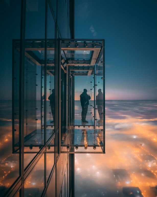 Person enjoying beautiful view city balcony with glass walls (Medium)